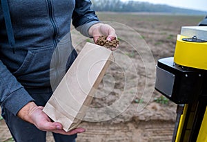 Soil Sampling. An engineer employee of a research laboratory packs a soil sample in a paper package. Automated probe for soil