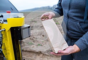 Soil Sampling. An engineer employee of a research laboratory packs a soil sample in a paper package. Automated probe for soil