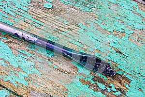 Soiled broken screwdriver on wooden background