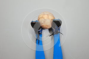 A soiled football on an upside down boots