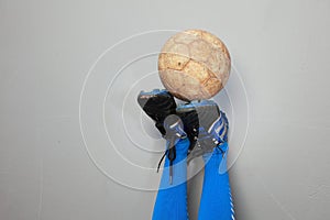 A soiled football on an upside down boots