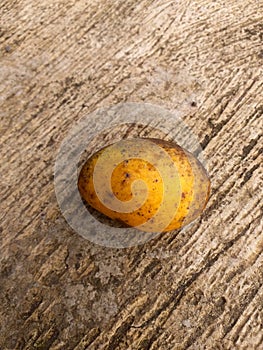 Soiled yellow fruit on cement floor