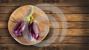 Solanum melongena - Two organic eggplants in the wooden bowl