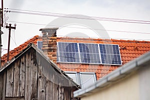 Solar battery on the roof of a house against the background of an old chimney and an old wooden roof