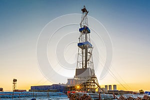 Solar bokeh under a well drilling rig.