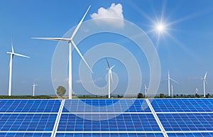 solar cells and wind turbines generating electricity in power station on blue sky background