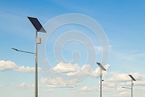 Solar device with street lamp on background of blue sky. Street light powered by solar panel with battery included. Alternative