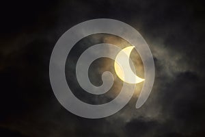 The solar eclipse in the cloudy sky