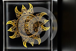 Solar Emblem A striking wall-mounted golden solar emblem, combining traditional motifs with modern presentation, creating a bold