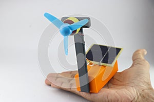 Solar energy absorbing solar panels that power small fan connected to a dc motor held in hand
