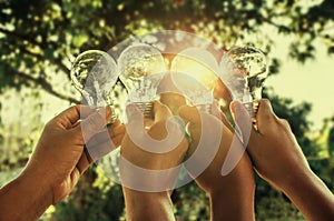 solar energy concept hand group holding light bulb