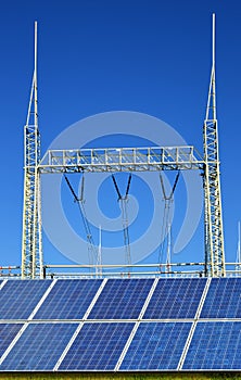 Solar energy panels in the background high voltage power substation.