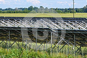 solar energy photovoltaic panels on green field and sky background, green clean alternative energy concept
