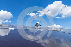 The solar farm with the technician is removing the nut to replace the damaged solar panel, Alternative energy to conserve the