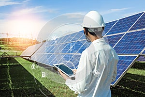 The solar farmsolar panel with engineers is checking the operation of the system by laptop, Alternative energy to conserve the