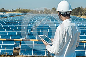 The solar farmsolar panel with engineers walk to check the operation of the system by laptop, Alternative energy to conserve the