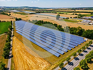 Solar field with solar panels on an agricultural field in sunshine