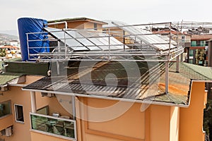 Solar glass water panel array mounted on a roof for heating. Huge tank for hot water. Heater with green energy for a hotel needs