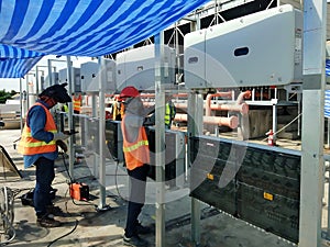 The solar inverters are installed by an electrician for the solar rooftop of the factory building