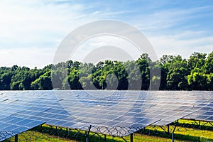 Solar panel on blue sky background. Green grass and cloudy sky.