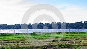 Solar panel on blue sky background. Green grass and cloudy sky.