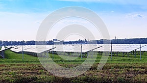 Solar panel on blue sky background. Green grass and cloudy sky.