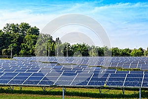 Solar panel on blue sky background. Green grass and cloudy sky.