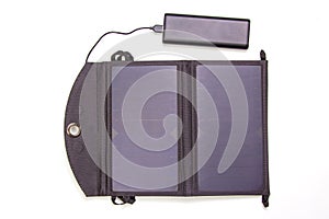 The solar panel charges the power bank battery for the smartphone on a white background. digital technologies and devices