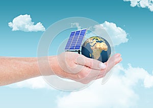 solar panel and earth on hand in the sky