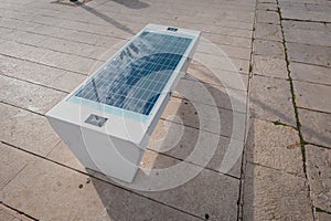Solar panel equipped bench on a beach at mali losinj, used to charge mobile phones and other battery powered appliances using the