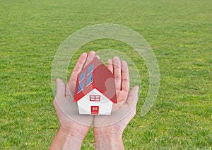 solar panel house with red roof on hands