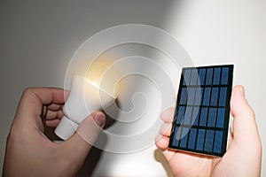 Solar panel and light bulb in hand