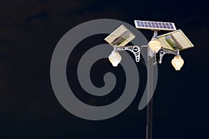 Solar panel lighting pole with night sky and white clouds.