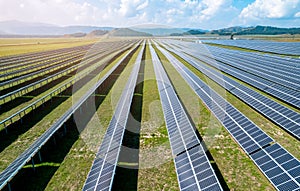 Solar panel, photovoltaic among mountains and hills Aerial view drone. Power farm producing clean green energy