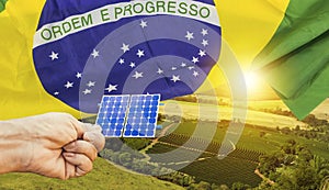 Solar panel photovoltaic plant with brazilian flag at sunset