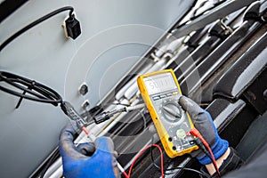 Solar panel on a roof being tested for its power output using a multimeter