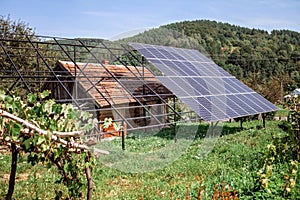 A solar panel on the roof on old wooden house at mountain countryside, green energy