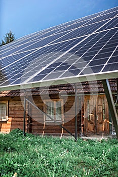 A solar panel on the roof on old wooden house at mountain countryside, green energy