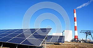 Solar panel, smokestack at power plant