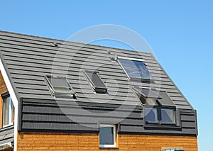 Solar panel and solar water heater on the modern house roof with skylights and dormer outdoor for energy efficiency.