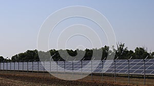 solar panel station in a field behind a metal fence