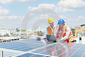 Solar panel technician on roof. Engineer and Young technician discussing project with laptop of solar power station