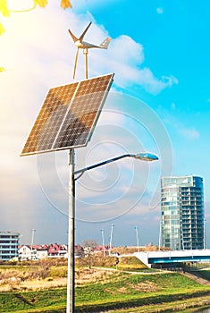 Solar panel, wind turbine under cloudy blue sky