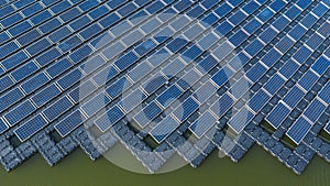 Solar panels in aerial view, rows array of polycrystalline silicon solar cells or photovoltaics in solar power plant floating on photo