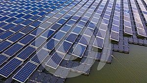Solar panels in aerial view, rows array of polycrystalline silicon solar cells or photovoltaics in solar power plant floating on