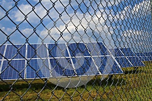 Solar panels behind rusty fence