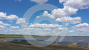 Solar panels at the field with the beautiful clouds at sunny summer day