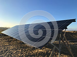 Solar panels in a field with sunray flare, evening light