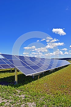 Solar panels on field under clear blue sky
