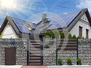 Beautiful modern house with solar panels. Clear sky, sun photo